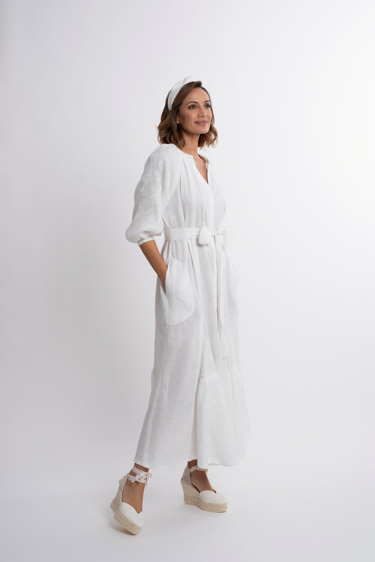 Ibiza: Vestido de lino blanco bordado con cinturón, pompones y botones de nácar.