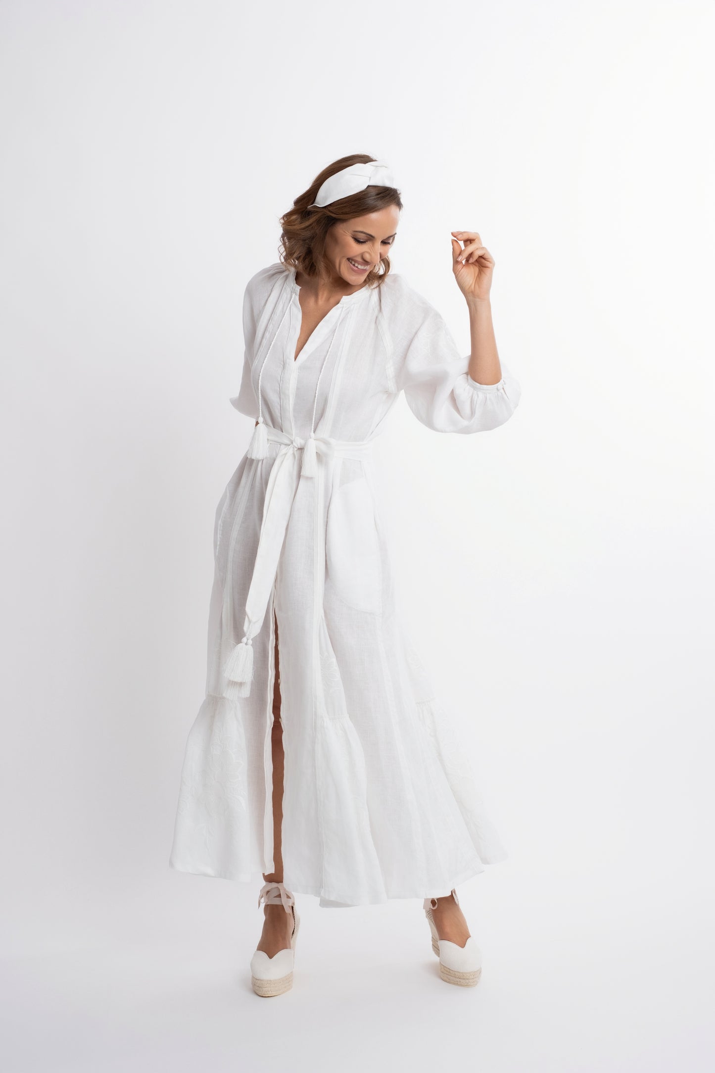 Ibiza: Vestido de lino blanco bordado con cinturón, pompones y botones de nácar.