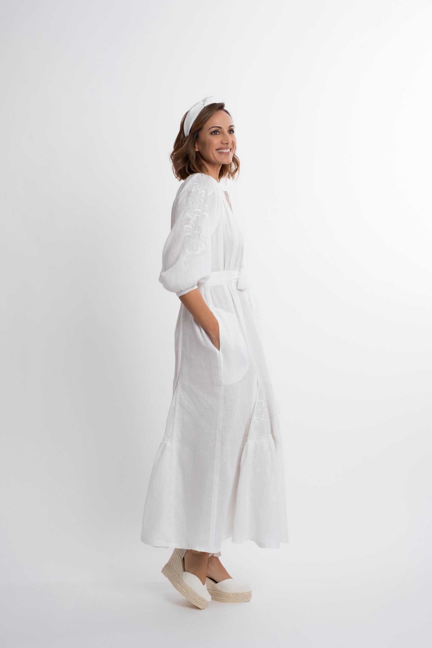 Ibiza: Vestido de lino blanco bordado con cinturón, pompones y botones de nácar.