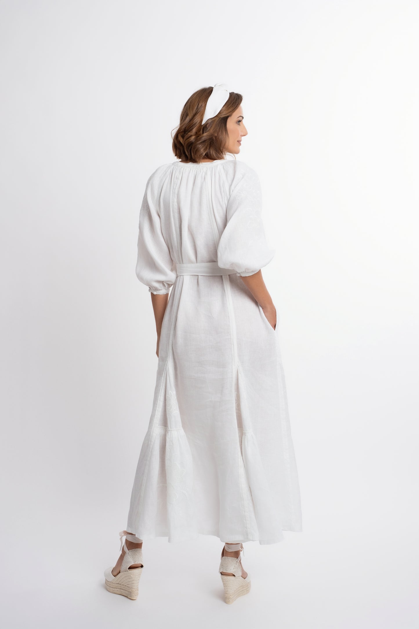 Ibiza: Vestido de lino blanco bordado con cinturón, pompones y botones de nácar.