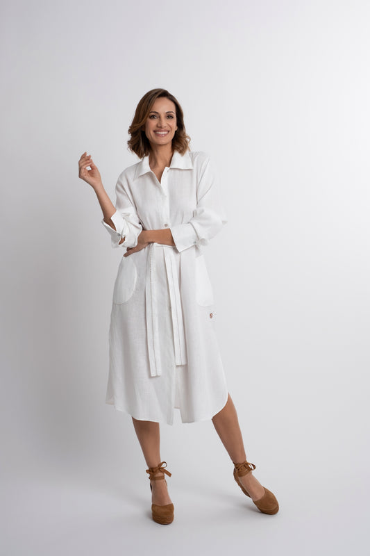 Dubai: Vestido camisero de lino blanco con cinturón, con bordado de pespunte en contraste y botones de nácar.