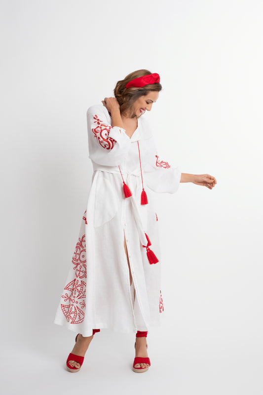 Santorini: Vestido de lino blanco con cinturón, bordado en rojo con pompones y botones de nácar.
