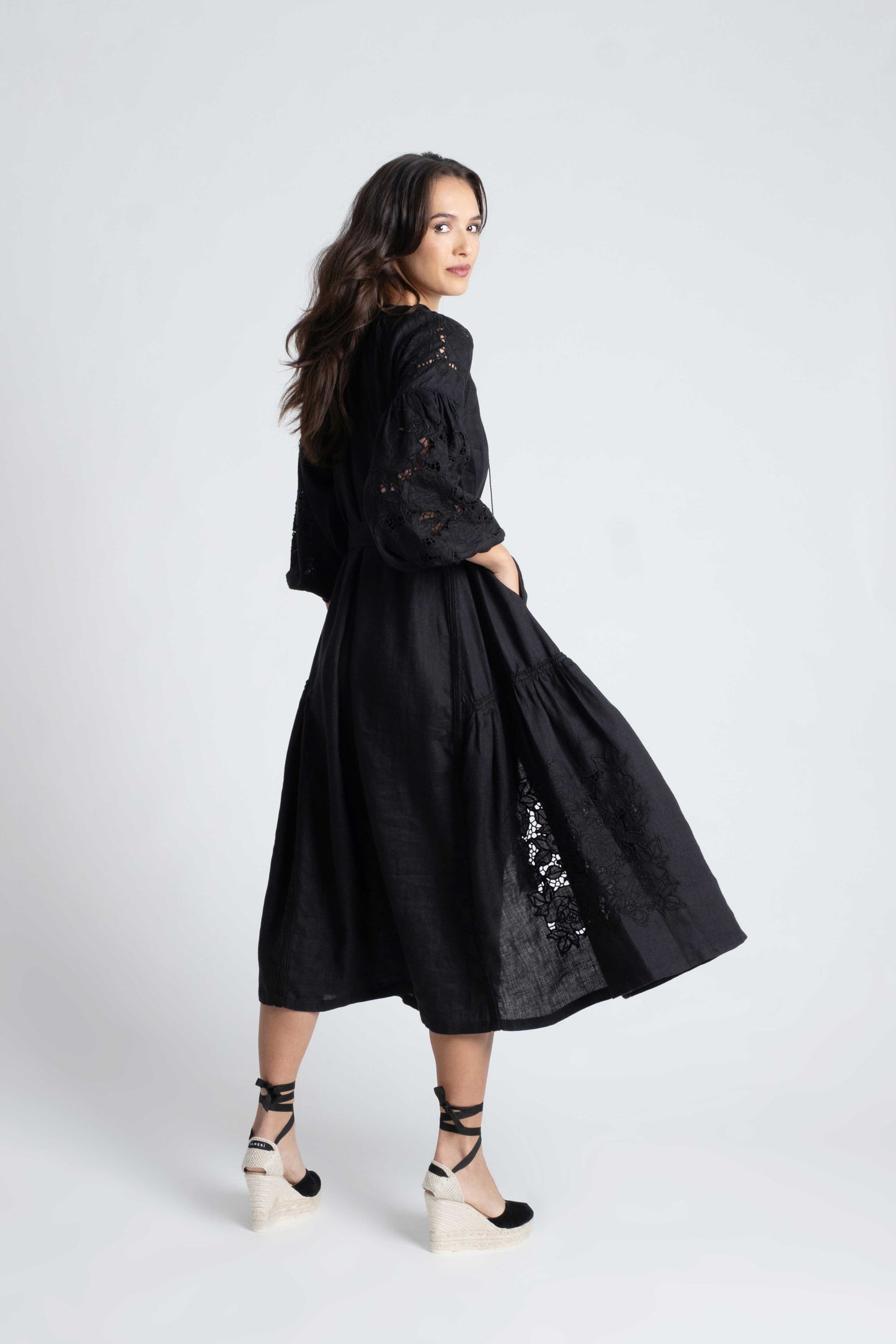 Capri: Vestido de lino negro con bordado suizo, pompones y botones de nácar.