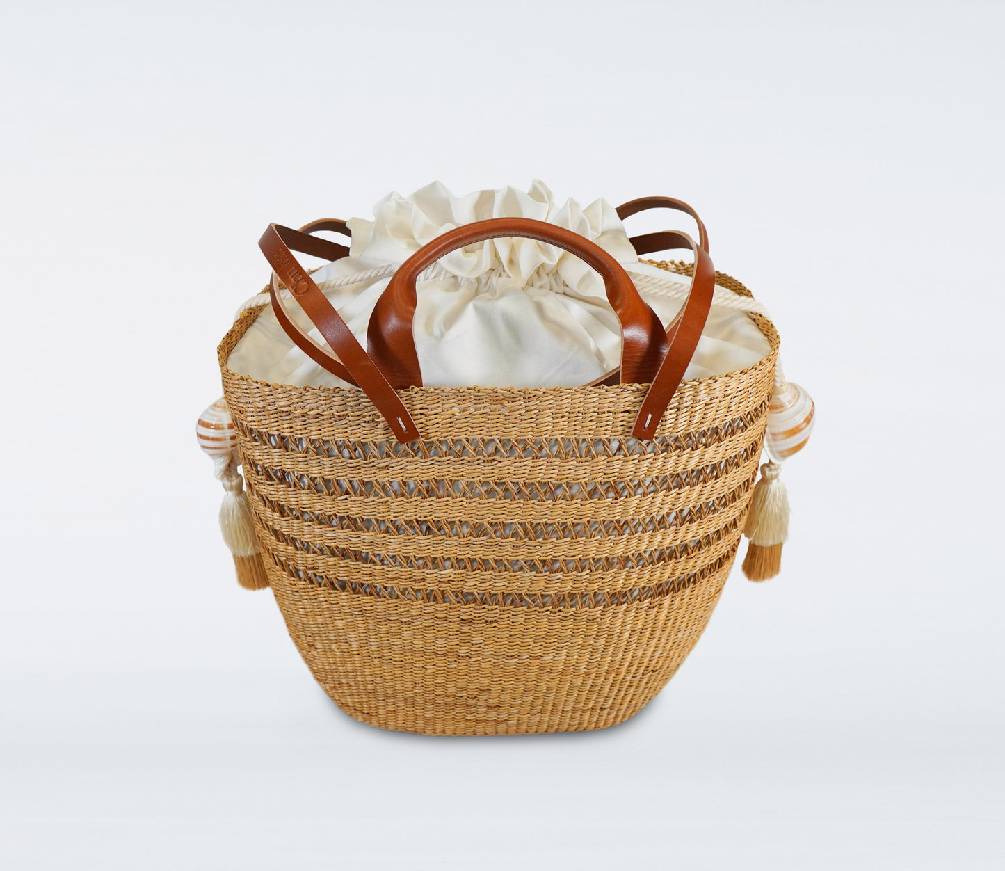 Milos: Large camel basket in straw, camel recycled leather handles, cotton bag and natural shells.