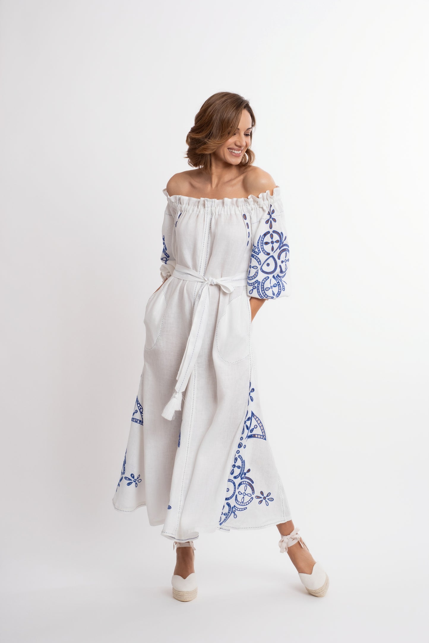 Mikonos: Vestido de lino blanco con escote de barco y cinturón, bordado en azul.