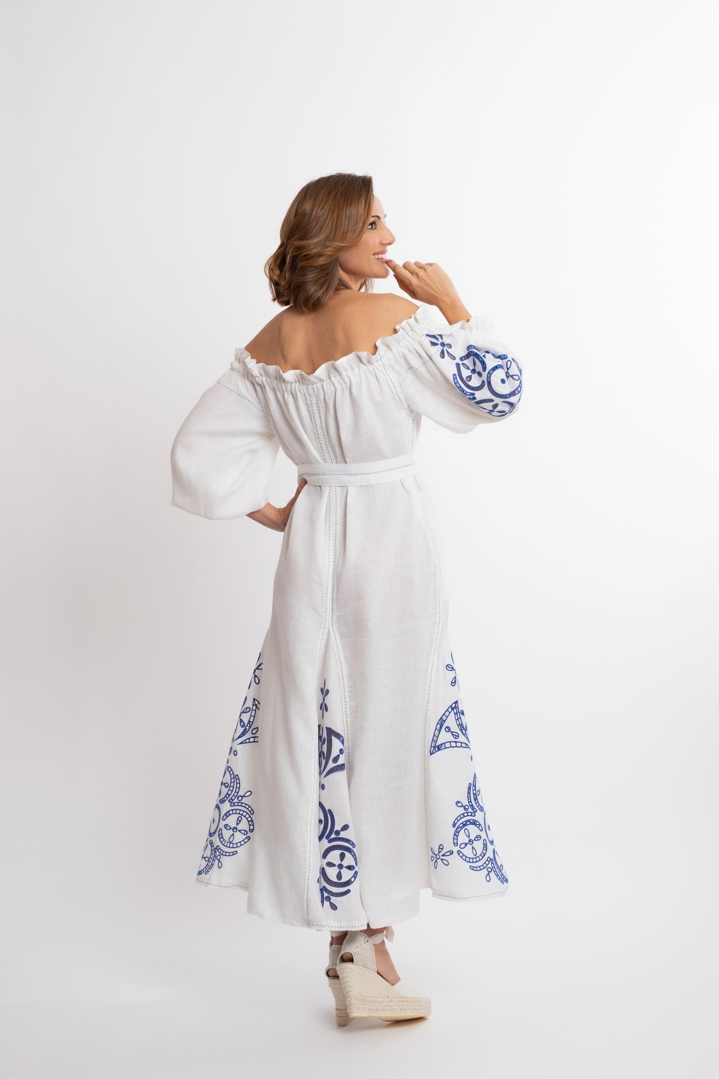 Mikonos: Vestido de lino blanco con escote de barco y cinturón, bordado en azul.