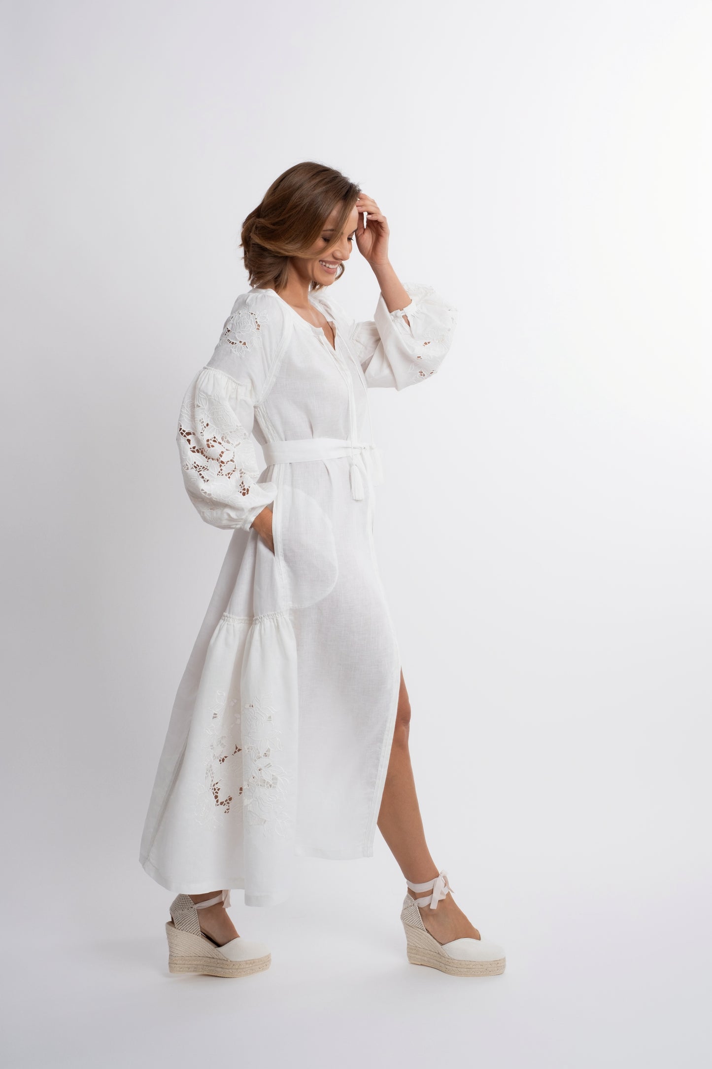 Capri: Vestido de lino blanco con cinturón, bordado suizo con pompones y botones de nácar.