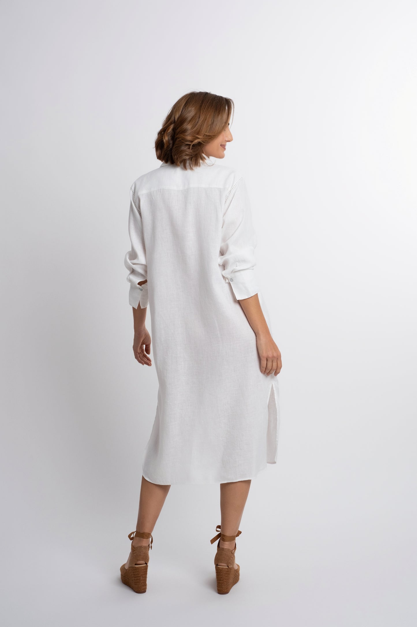 Dubai: white linen shirt belted dress with contrasting topstitch embroidery and mother of pearl buttons.