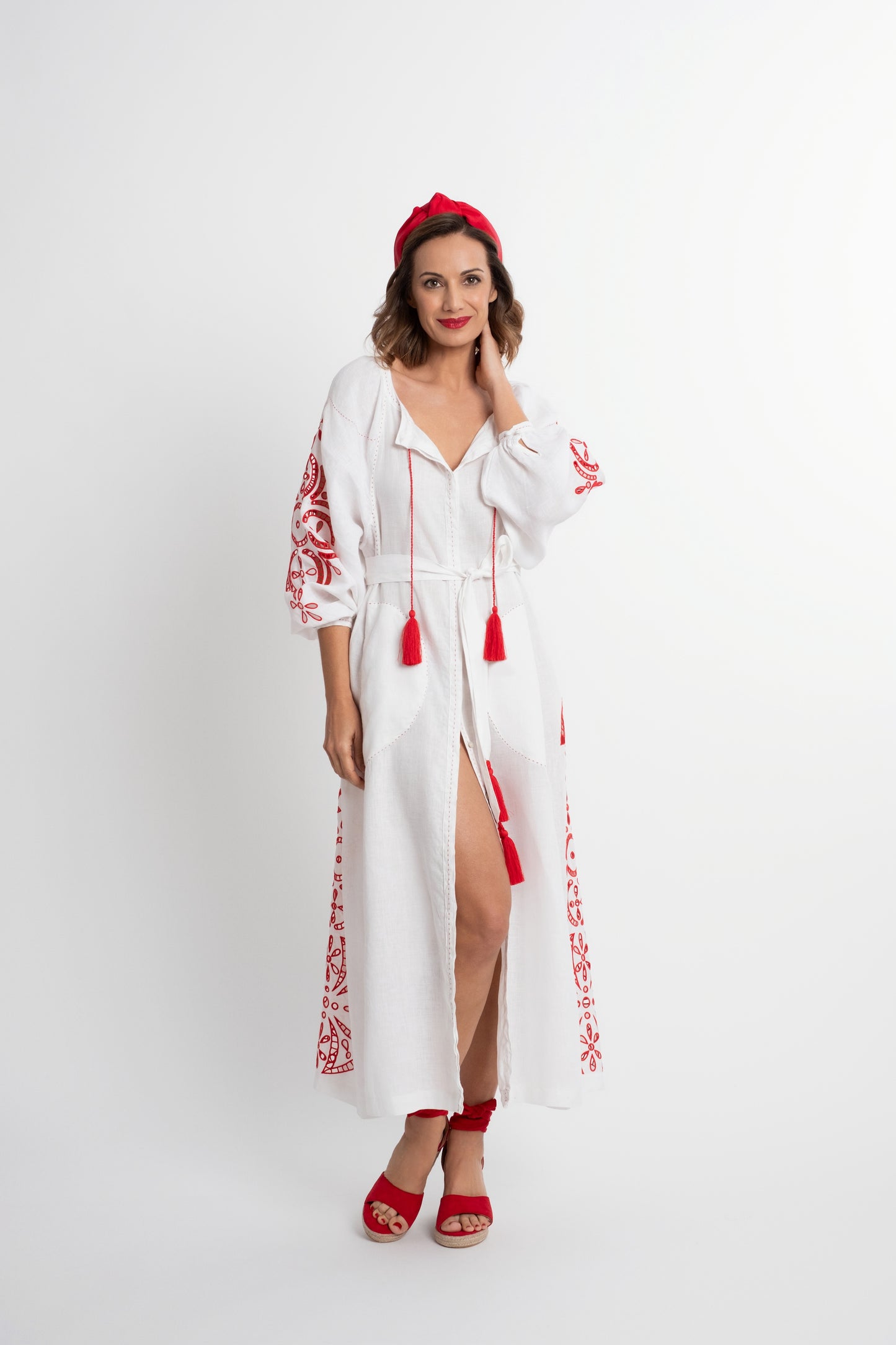 Santorini: Vestido de lino blanco con cinturón, bordado en rojo con pompones y botones de nácar.