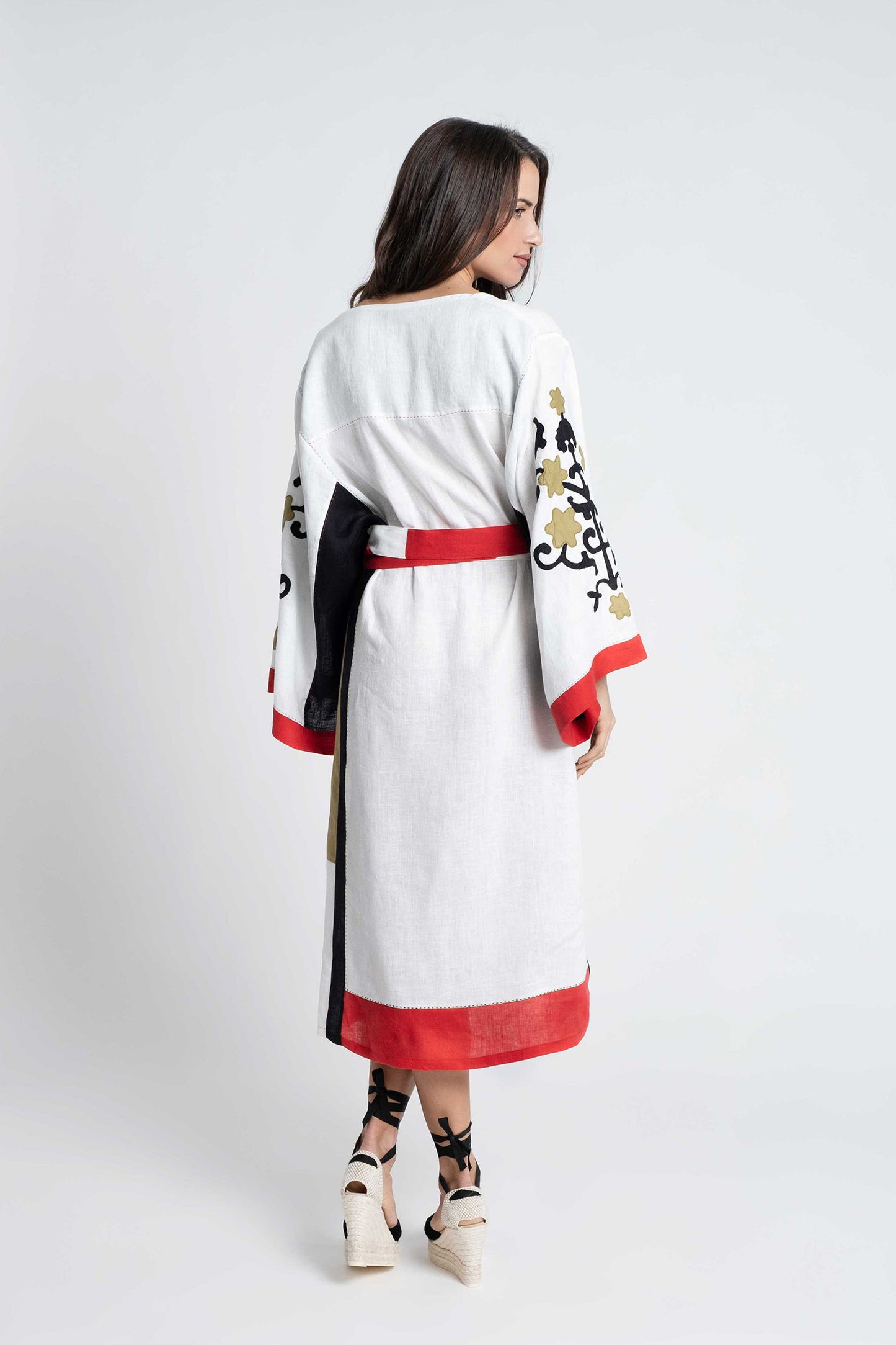 White linen belted dress embroidered in black, red and olive.