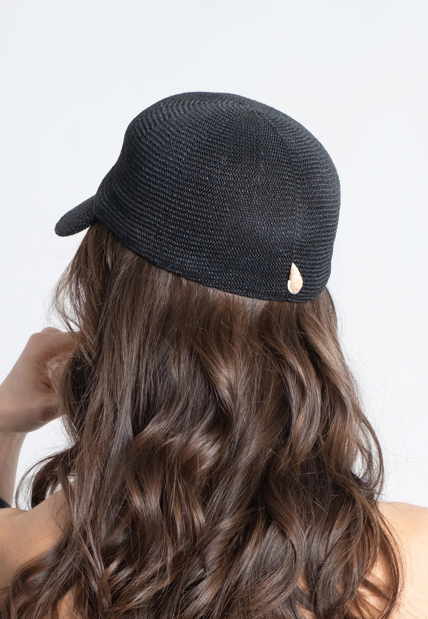 Black straw cap with natural shell.