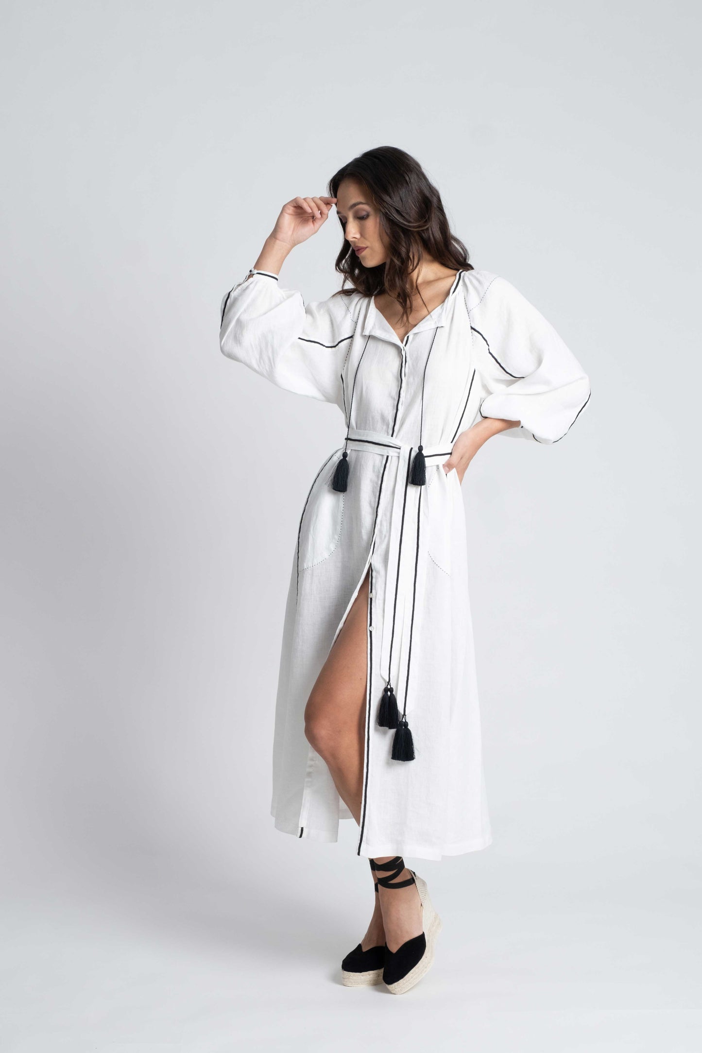 White linen belted dress embroidered in black with pompons and  mother of pearl buttons.