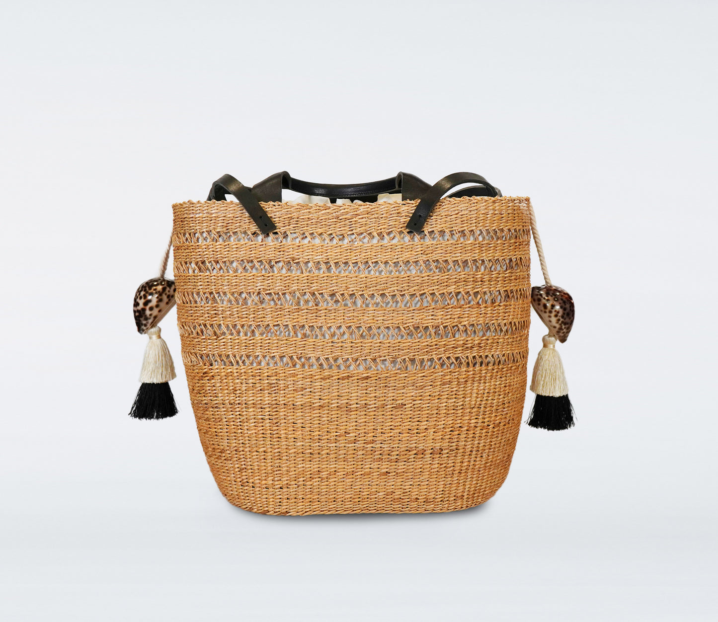 Large black basket in straw, black recycled leather handles, cotton bag and natural shells.