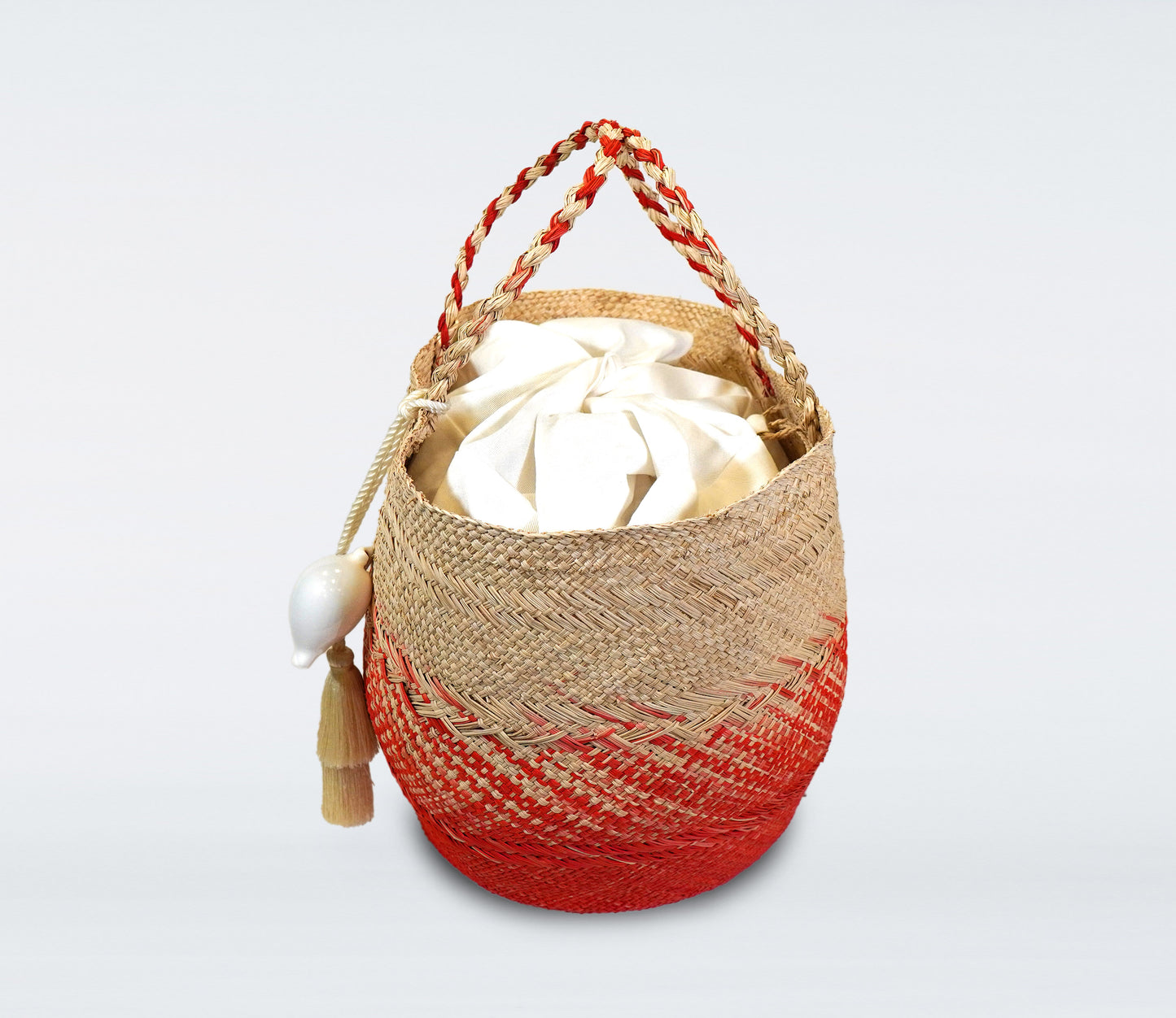 Medium red basket in straw, cotton bag and natural shell.